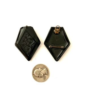 Pair of black rhombus pins. Quarter used for scale